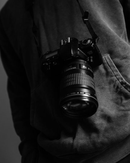 Ein schwarz-weiß Bild von einer Kamera, die jemand umgehängt hat